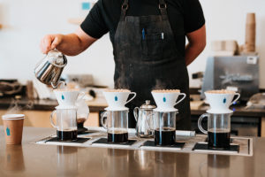 Barista an der Kaffeebar mit Handfiltern