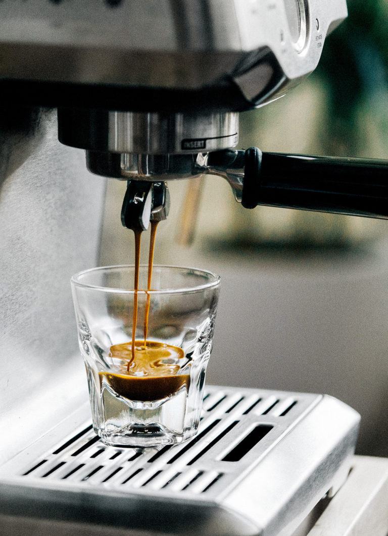 Espresso läuft aus dem Siebträger in ein Glas