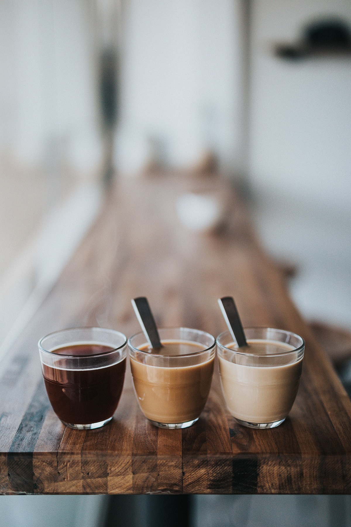 Drei Kaffeegetränke auf einer Bar